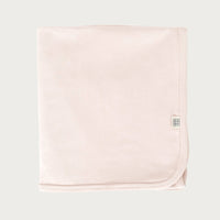 Petal pink cotton baby blanket with a brand logo on a light grey background