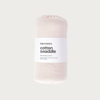 Petal coloured cotton swaddle with a label on a light grey background