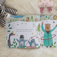 Open children's book with illustrated pages featuring animals and a bear, surrounded by plush toys on a soft surface.