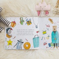 Illustrated children's book open to a page with colorful drawings on a soft surface.