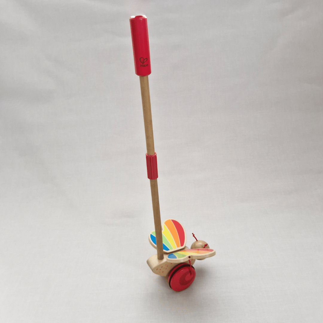 Toy with a red handle and colorful base on a white background