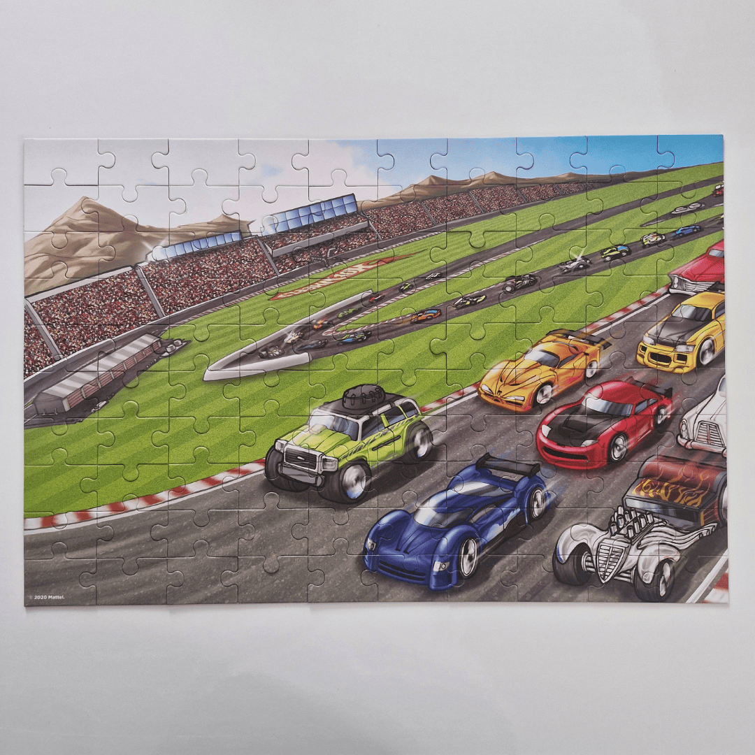 Jigsaw puzzle of a race track with colorful cars on a white background
