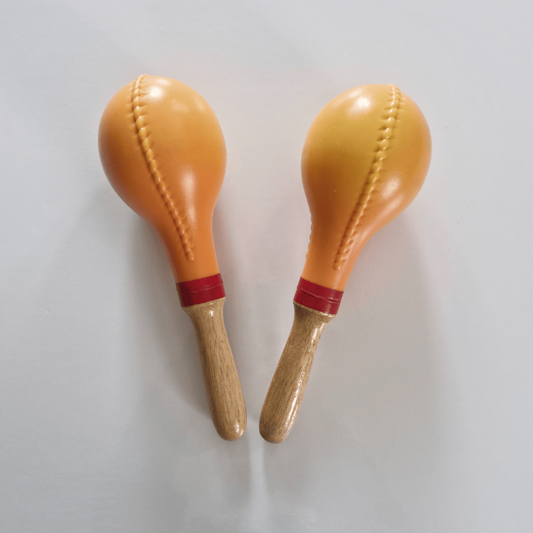 Two maracas with wooden handles on a light gray background