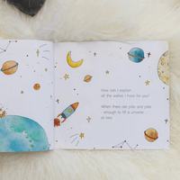 Open book with space-themed illustrations and text on a soft surface