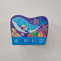 Colourful puzzle box with whale design on a light gray background
