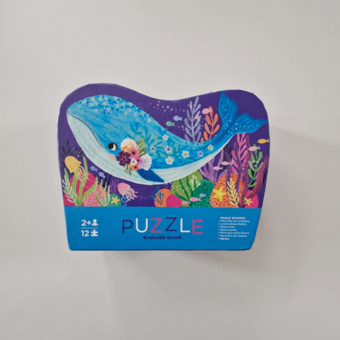 Colourful puzzle box with whale design on a light gray background