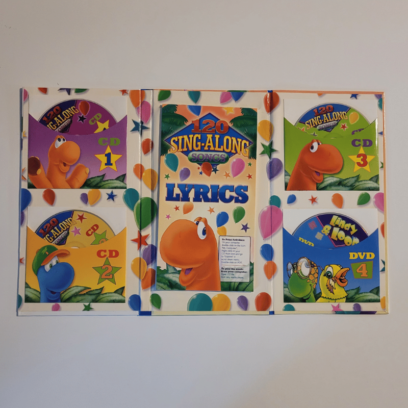 Set of colourful children's music cds and song book on a white background