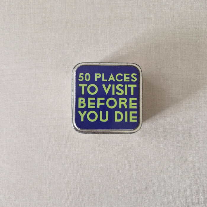 Square metal tin with text '50 Places to Visit Before You Die' on a light gray background