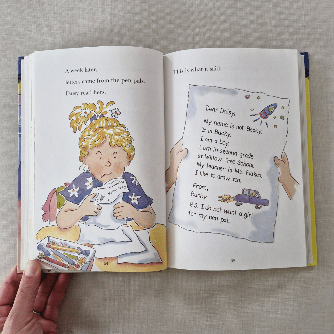 Open book showing a page with an illustration of a girl and text, held by a hand on a textured surface.