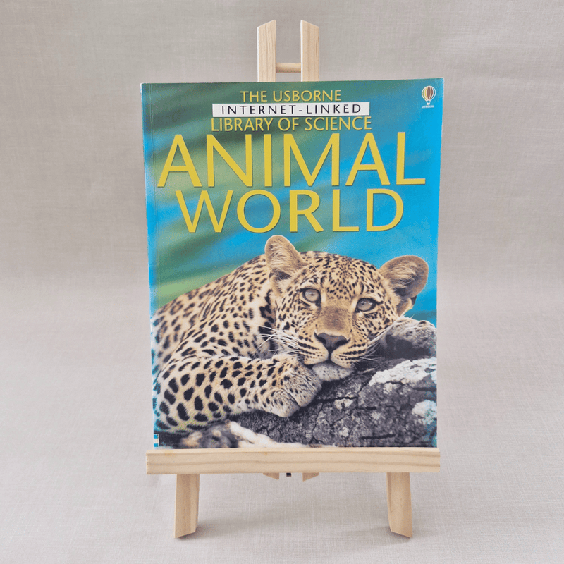 Book titled 'Animal World' by Usborne on a small easel against a light grey background