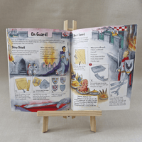 Open book with medieval-themed activities on a small wooden easel against a neutral background