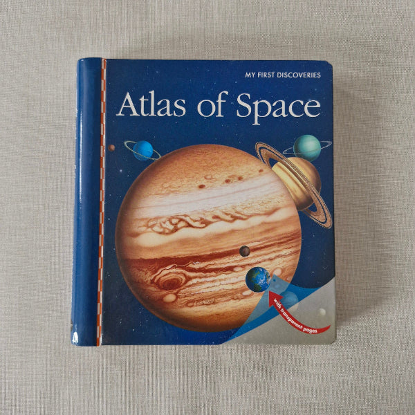 Book titled 'Atlas of Space' with a Jupiter illustration on a textured surface
