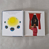 Open book with illustrations of earths rotation around the sun on a textured surface