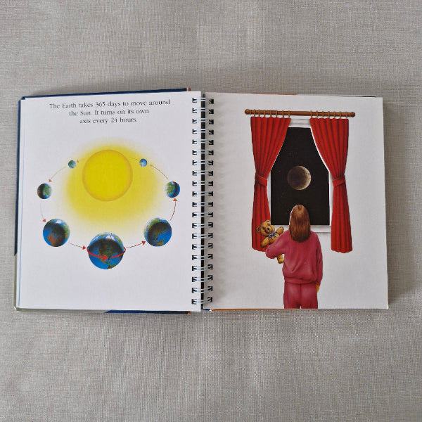 Open book with illustrations of earths rotation around the sun on a textured surface