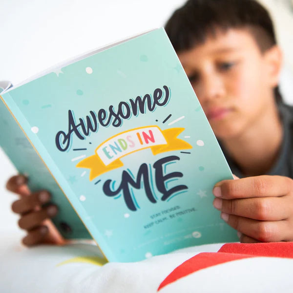 Child holding a book with 'Awesome ends in me' on a light background