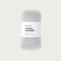 Sky blue cotton swaddle with a white label on a light grey background