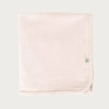 Petal pink cotton baby blanket with a brand logo on a light grey background