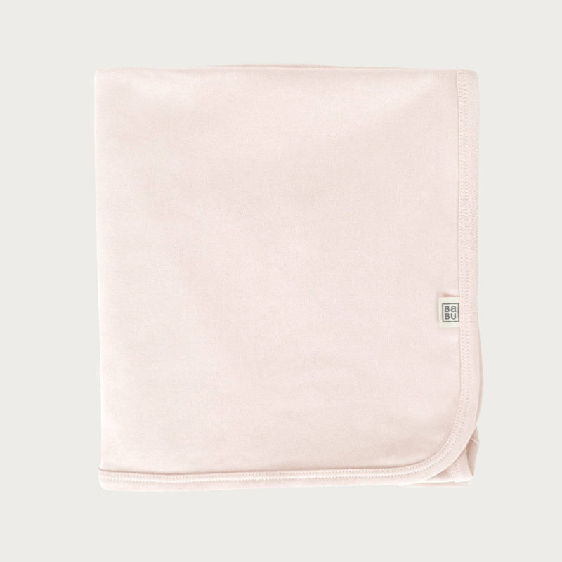 Petal pink cotton baby blanket with a brand logo on a light grey background