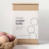 Box of babu basics cedar balls with a basket of cedar balls on a white background