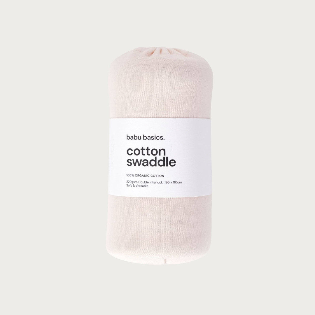 Petal coloured cotton swaddle with a label on a light grey background