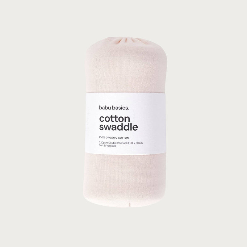 Petal coloured cotton swaddle with a label on a light grey background