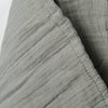 Close-up of sage muslin textured fabric with a white background
