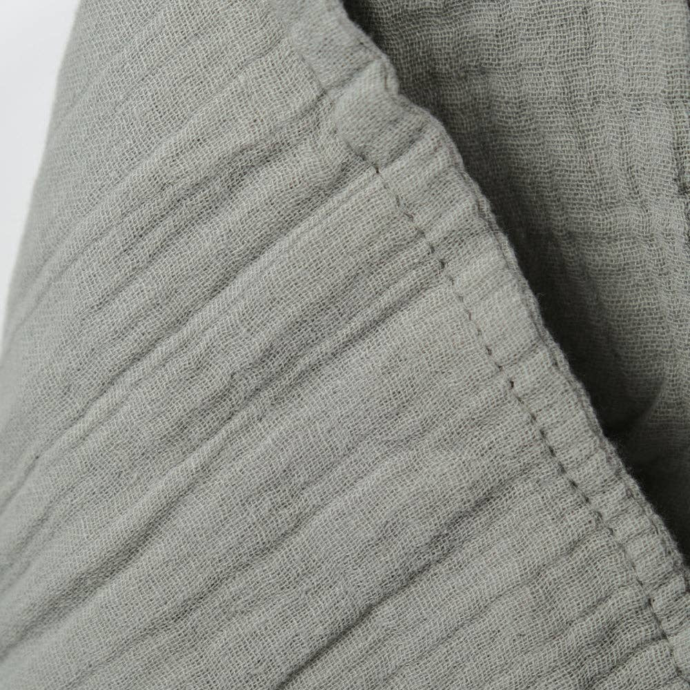 Close-up of sage muslin textured fabric with a white background