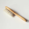 Wooden brush with soft goat hair bristles on a light grey background
