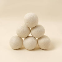 Stack of white 100% wool balls on a beige background