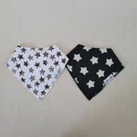 Two baby bandana bibs with star patterns on a beige background