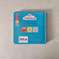 Back cover of a children's book titled 'Baby Colours' on a textured beige surface.