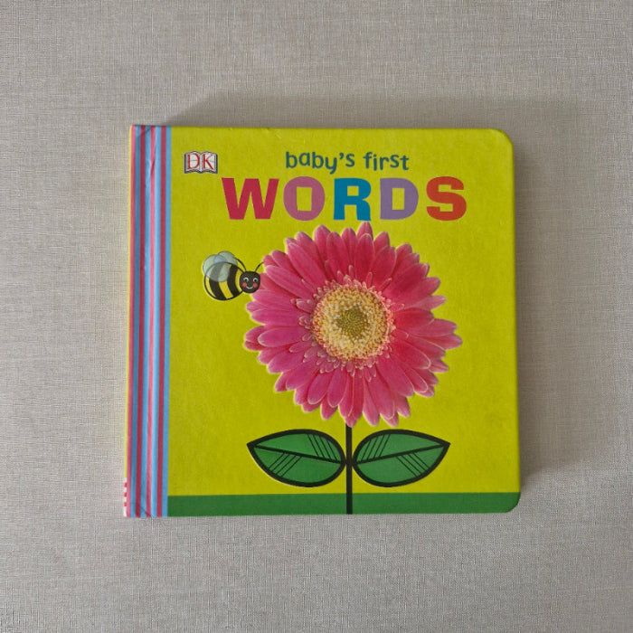 Children's book titled 'Baby's First Words' with a pink flower illustration on a yellow background.