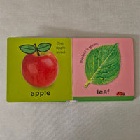 Two educational book pages showing a leaf and an apple on a textured surface.