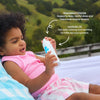 Child holding a bottle with text about magnesium chloride and lavender oil, outdoors.