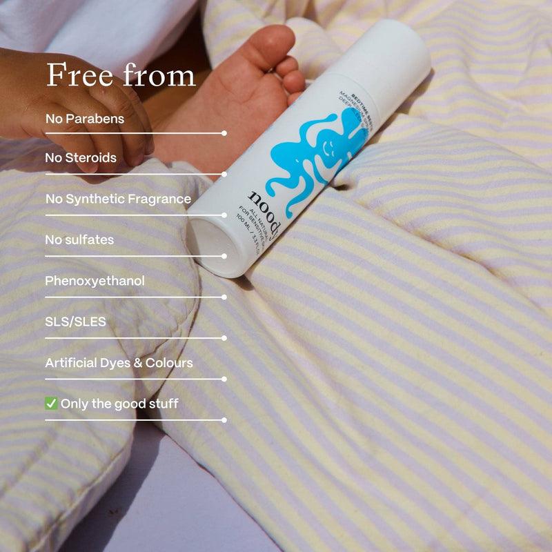 Product packaging with text highlighting ingredients free from, on a striped fabric background.