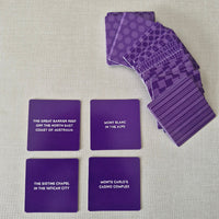 Purple playing cards with text on a textured surface
