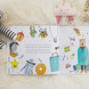 Illustrated children's book open to a page with colorful drawings on a soft surface.