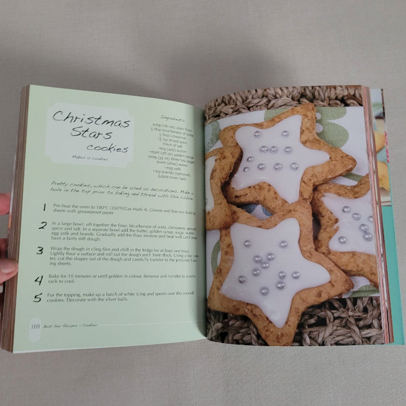 Open book showing a recipe for Christmas star cookies with a picture of the cookies on the cover.