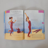 Open book showing illustrations of a person in a red outfit performing yoga poses on a plain background.