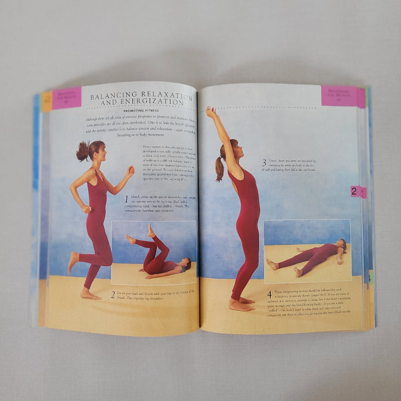 Open book showing illustrations of a person in a red outfit performing yoga poses on a plain background.