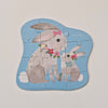 Children's puzzle with two bunnies holding flowers on a light gray background