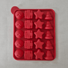 Red silicone mold with various shapes on a grey background