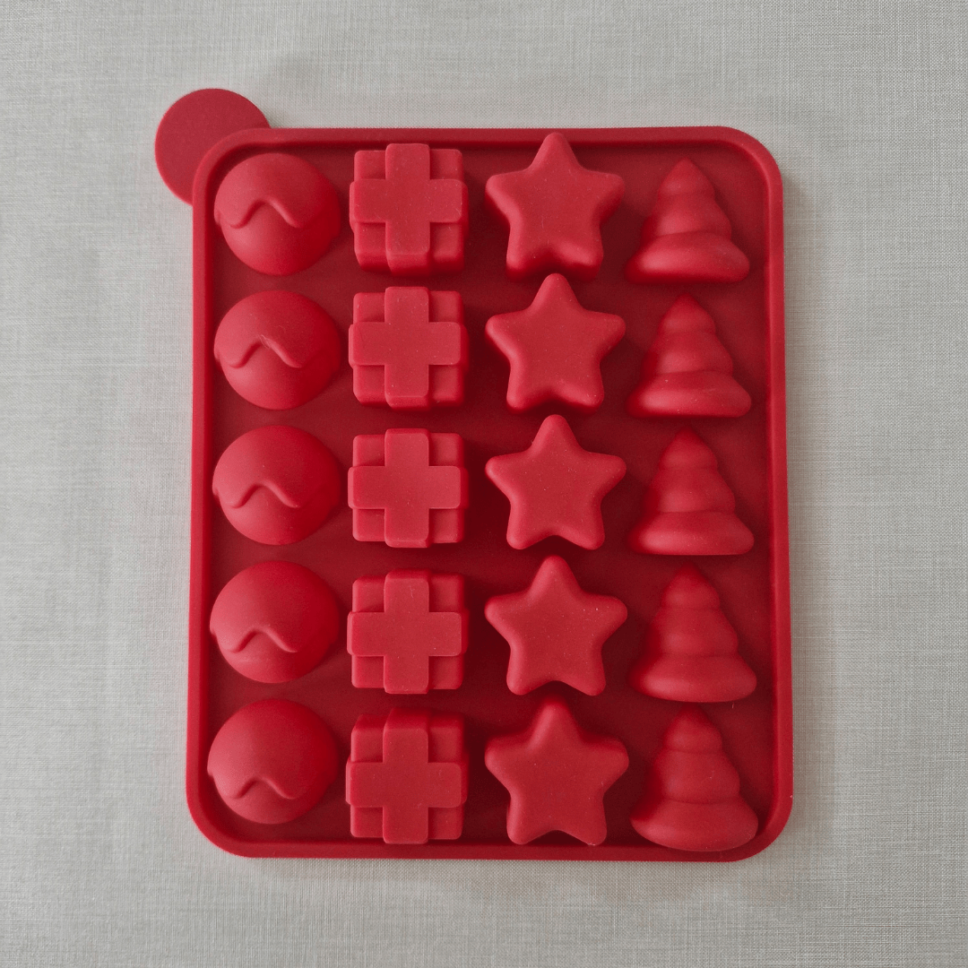 Red silicone mold with various shapes on a grey background
