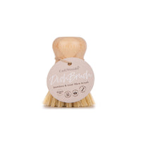 A beige dish brush with natural bristles and a bamboo handle, with a brand label attached to the handle.