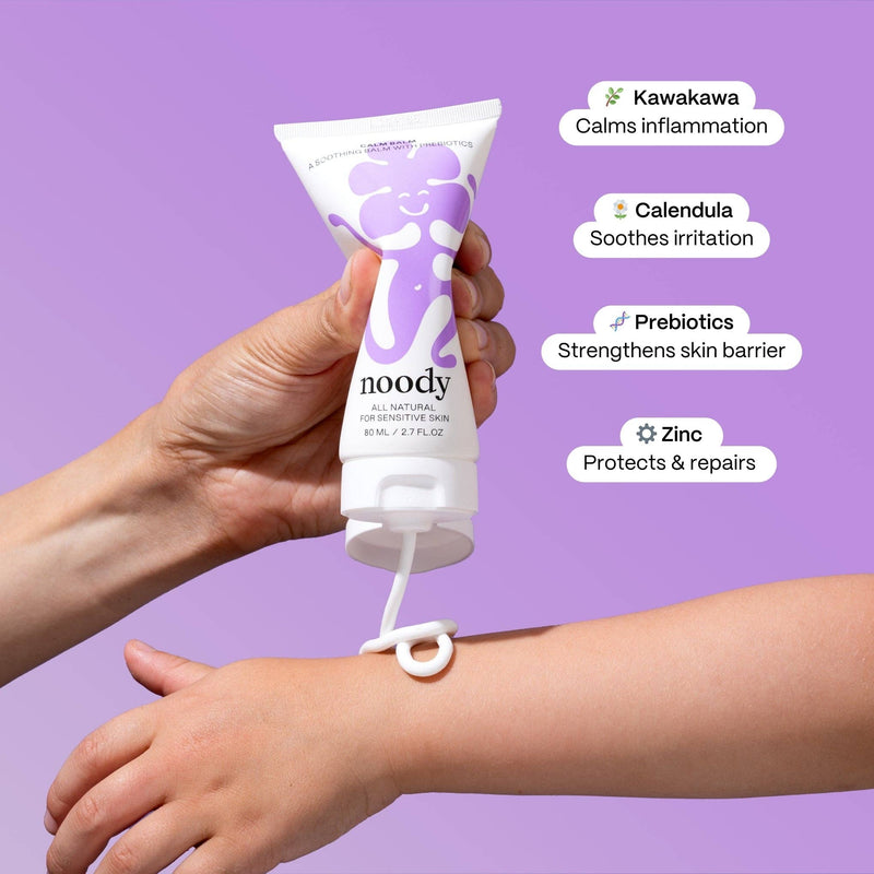 Hand applying noody cream to a wrist with purple background and text highlighting ingredients.