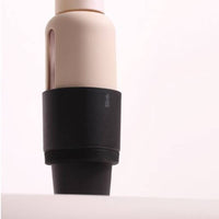 Beige water bottle with a black car cup holder on a white background