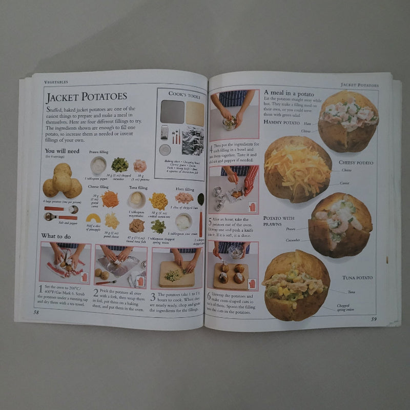 Open book with recipes and images of food on a gray background