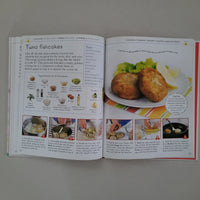 Open cookbook showing a recipe for tuna fishcakes with images and text.