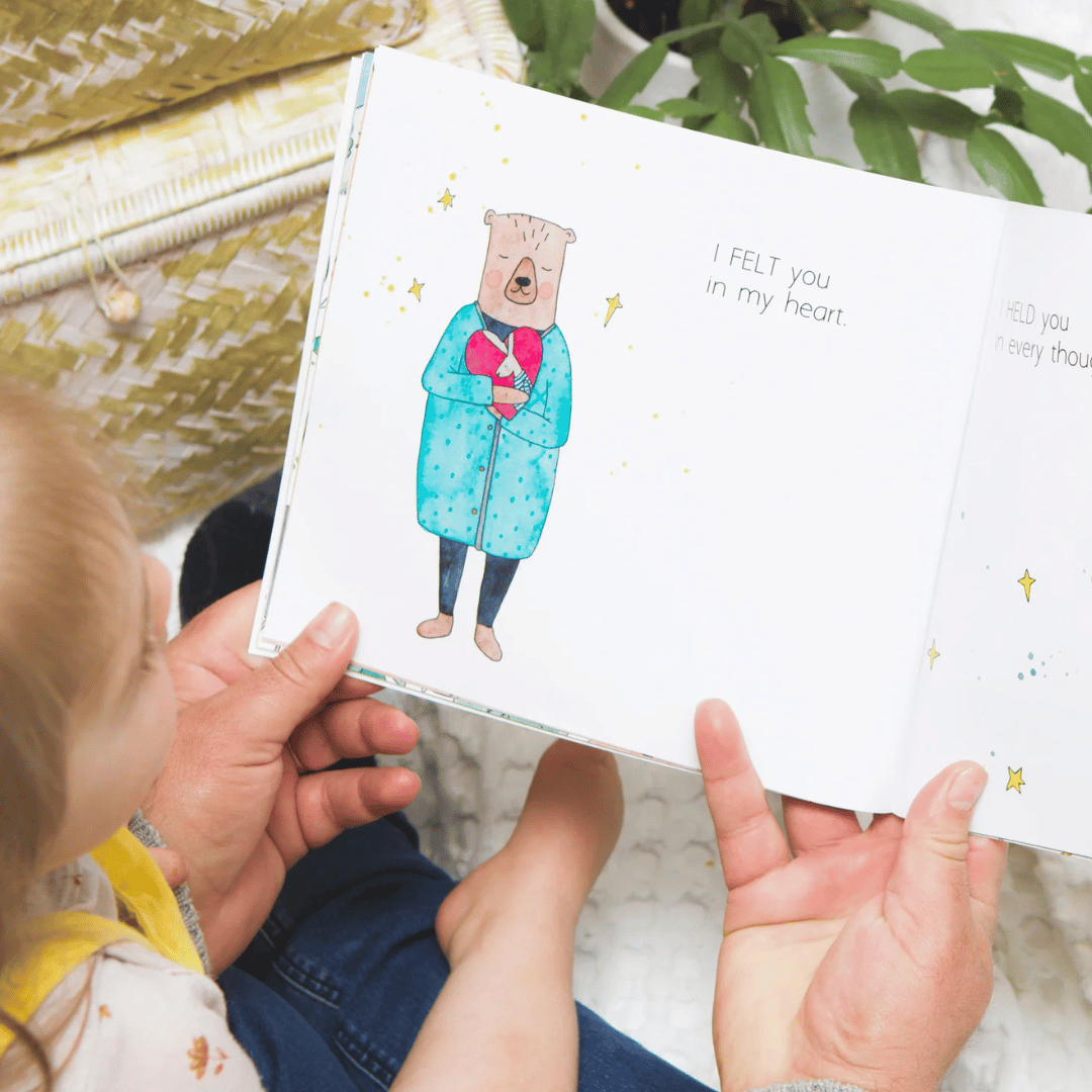 Child reading a book with a bear illustration on a soft surface