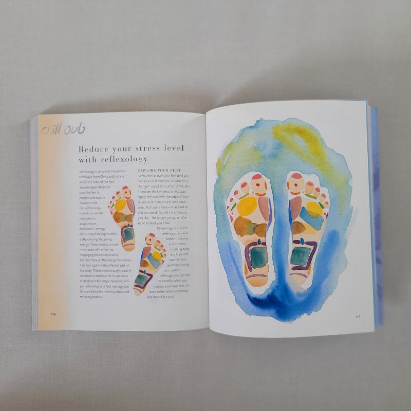 Open book with colourful reflexology footprints on a gray background